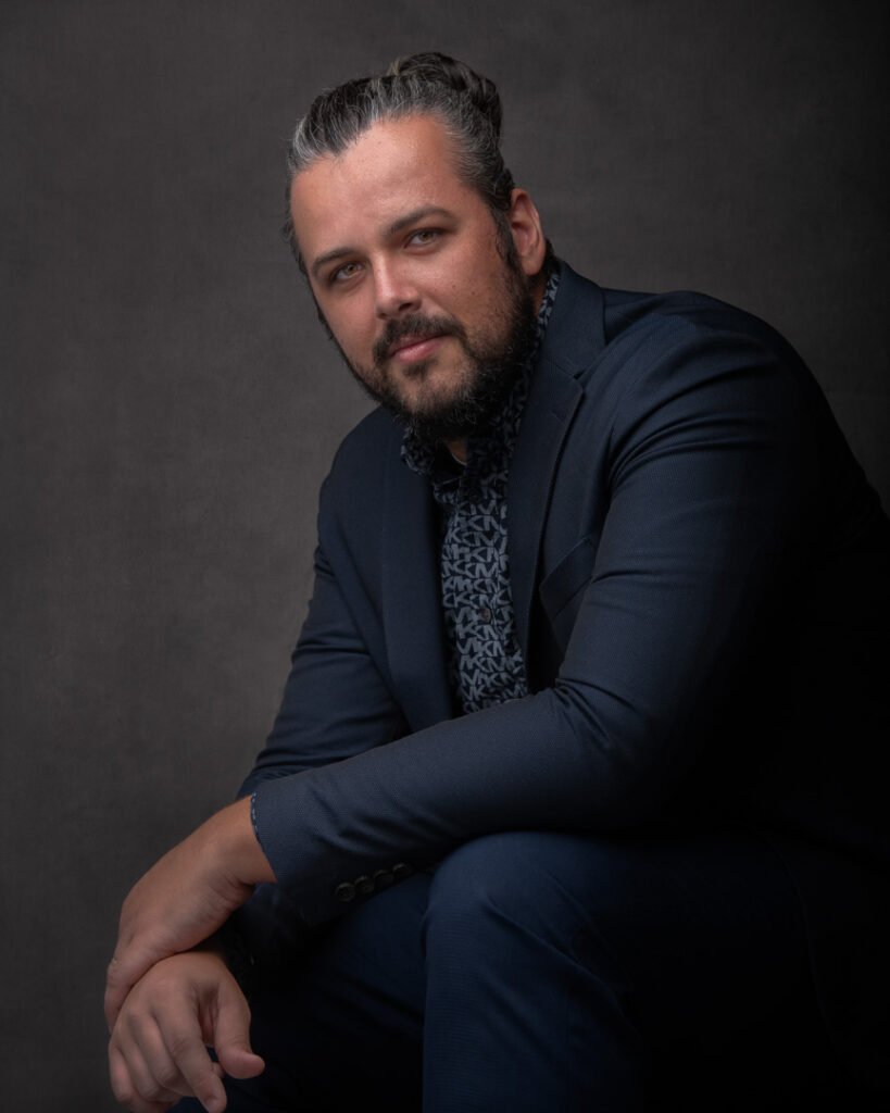 A professional man in a nice blue suit posing with his arms crossed and looking into the camera