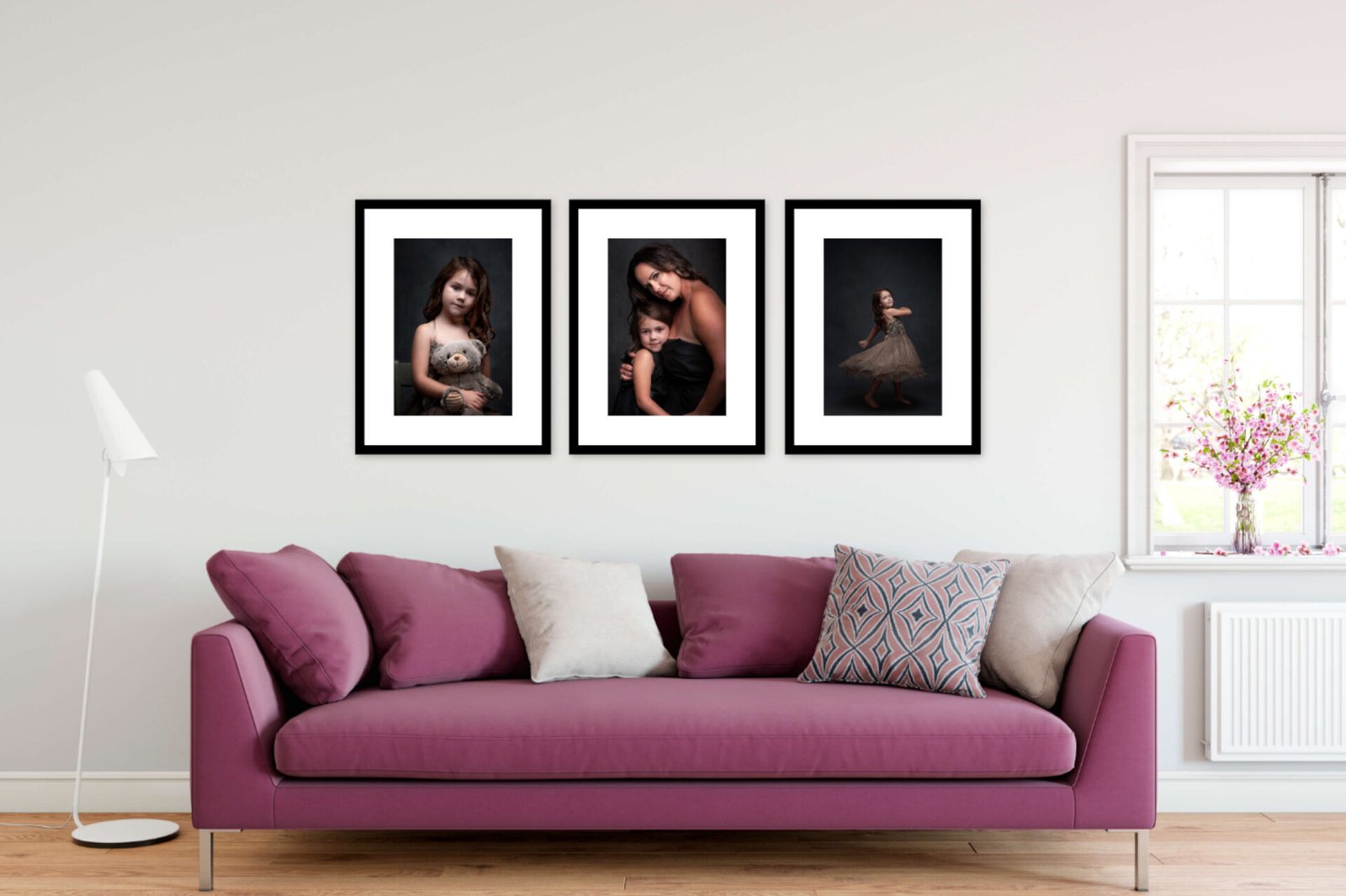 Three framed portraits of a mother and daughter, hanging on a wall over a purple couch.